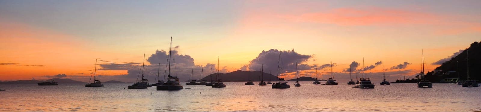 Caribbean harbor at dusk with boats at anchor